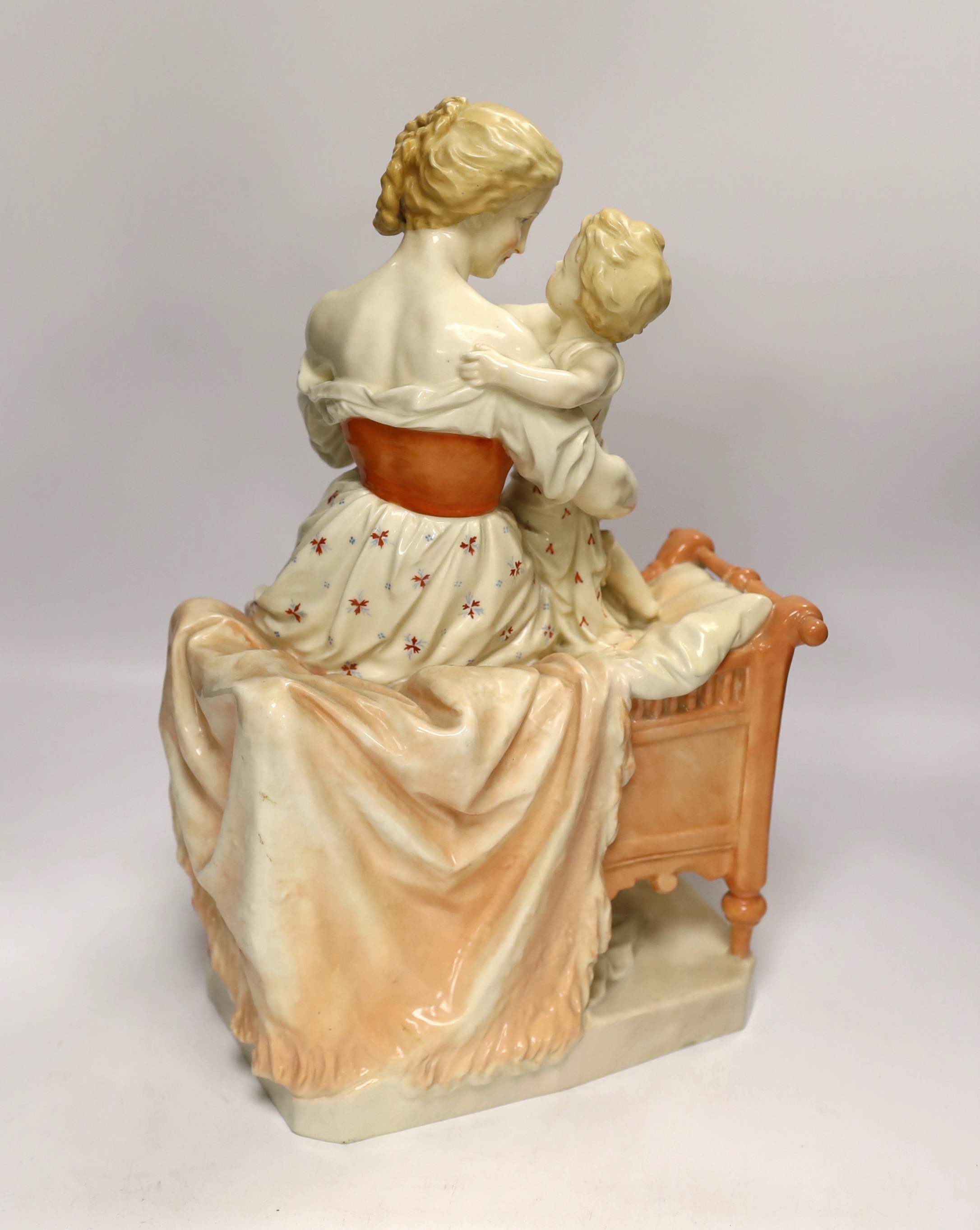 A large French porcelain seated ‘mother and child’ group and a pair of figural candlesticks, figure group 39cm high